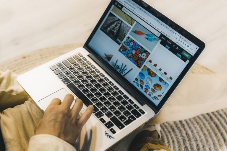 Căști pe laptop și pe telefon, fără bătăi de cap la birou Bărbat cu căști pe urechi, lucrând la laptop, cu telefonul lângă tastatură