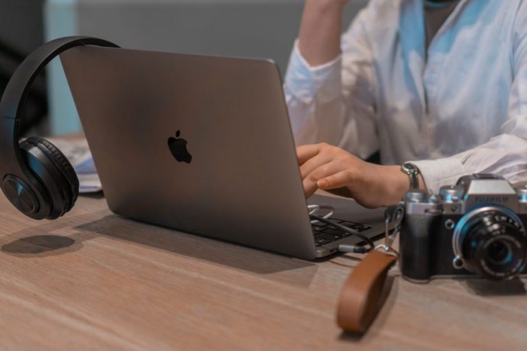 Cum arată o săptămână de freelancer care nu își pierde nopțile Un liber-profesionist cu căști lucrează la laptop, la o masă de lângă fereastră