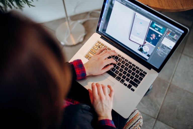 Ce se vede la un laptop după trei ani de folosire zilnică Femeie la laptop într-o cameră slab luminată, cu jucării de copil pe covor